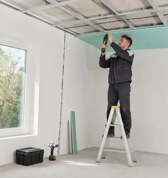 Worker installing a new drywall ceiling panel during ceiling water damage repair in Wisconsin Rapids, WI